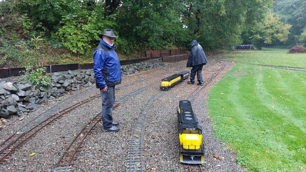 US Diesellokomotiven mit Personalen im Regenkombi.